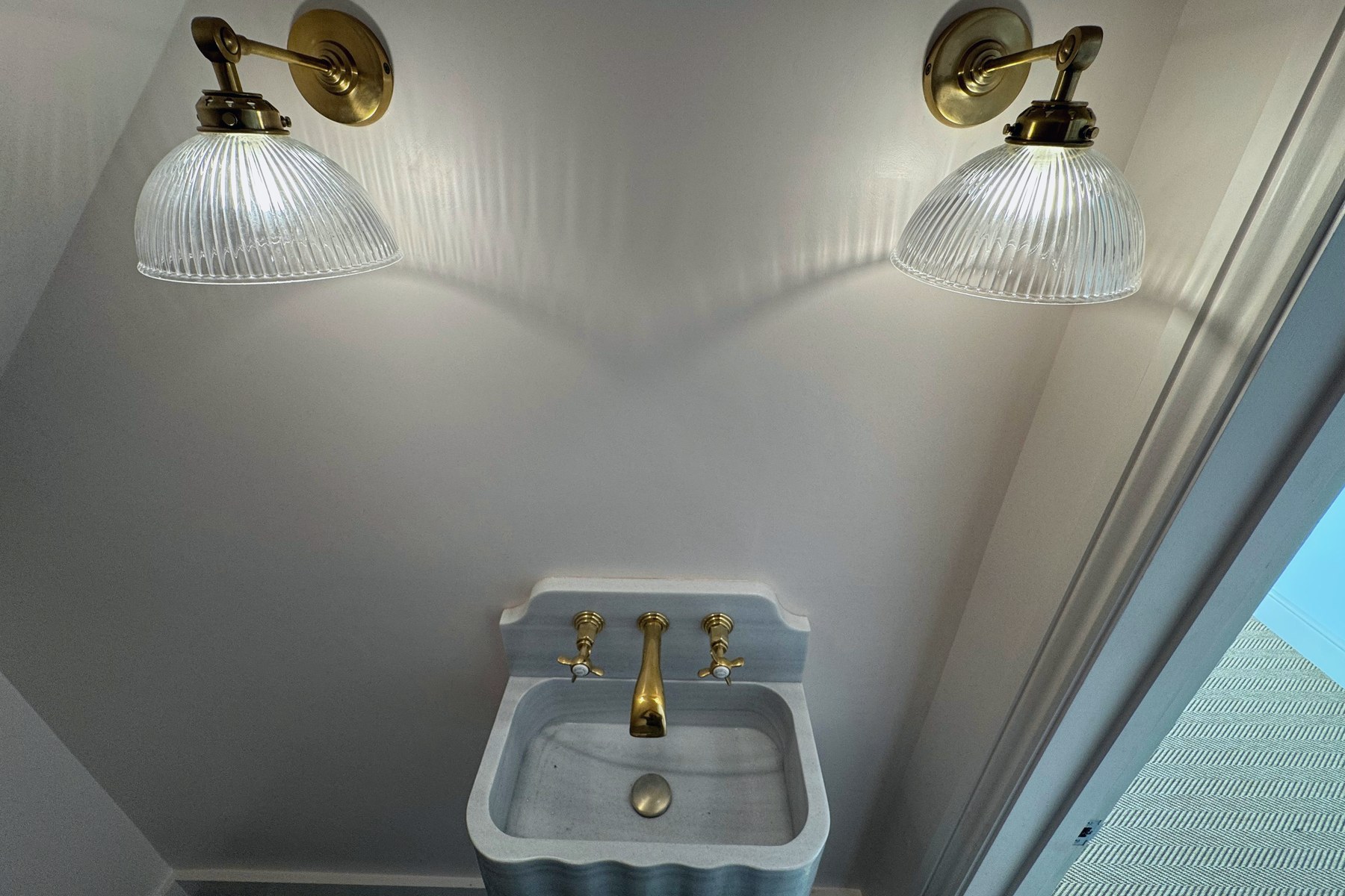 Marble vanity with brass taps and wall lights