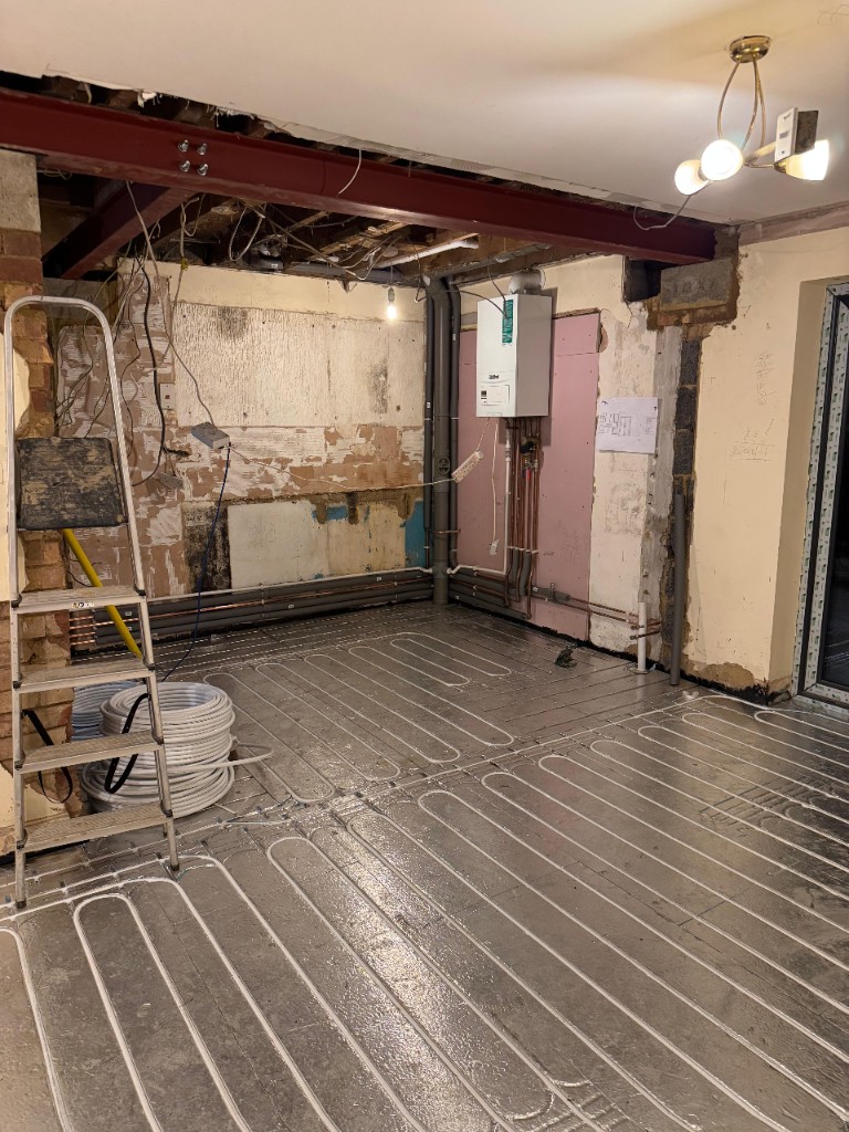 Warm-water underfloor heating pipes on insulation boards — professional layout before screed